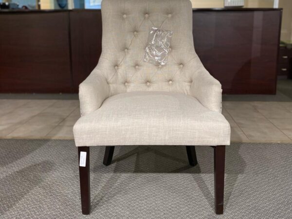 Upgrade your space with our Cream accent chair. Gold studs and dark brown legs bring a touch of sophistication. Stylish, comfortable, and perfect for enhancing any room's ambiance.